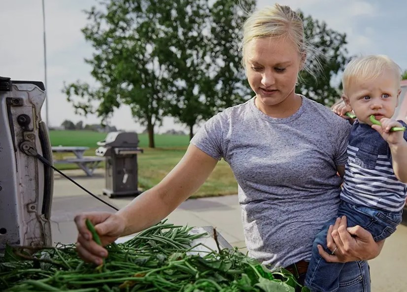 En mamma håller sitt lilla barn utomhus