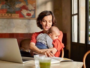 Mamma håller sin baby och kommunicerar med babytecken i hemmiljö