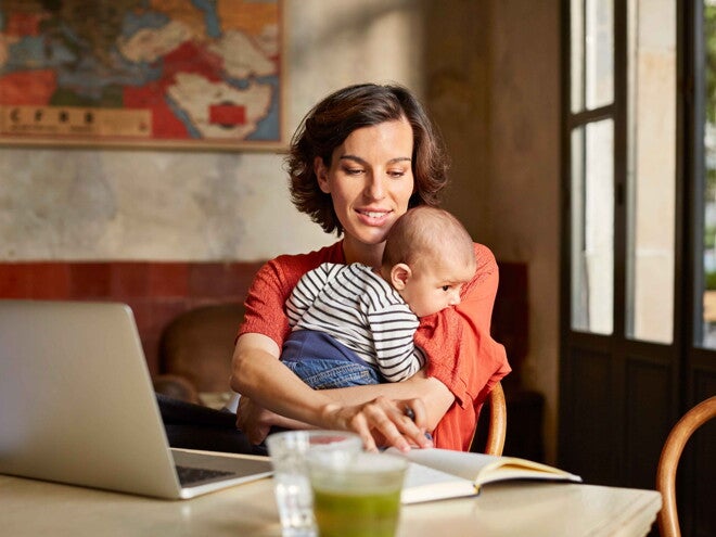 Mamma håller sin baby och kommunicerar med babytecken i hemmiljö