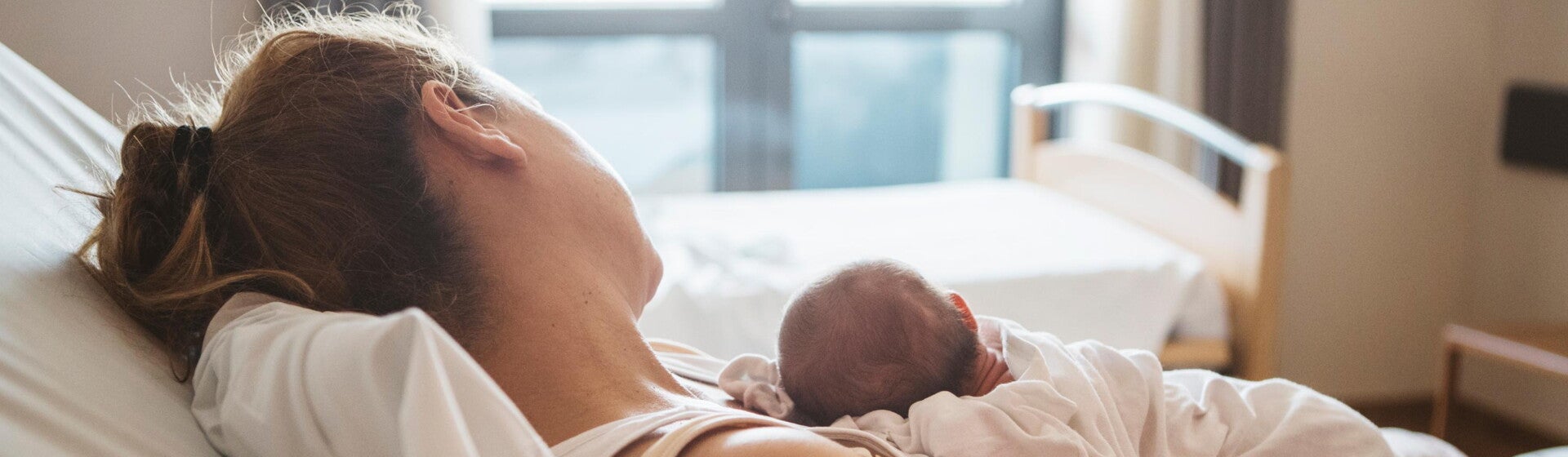 Förlossning Avslappnad kvinna med bebis på magen